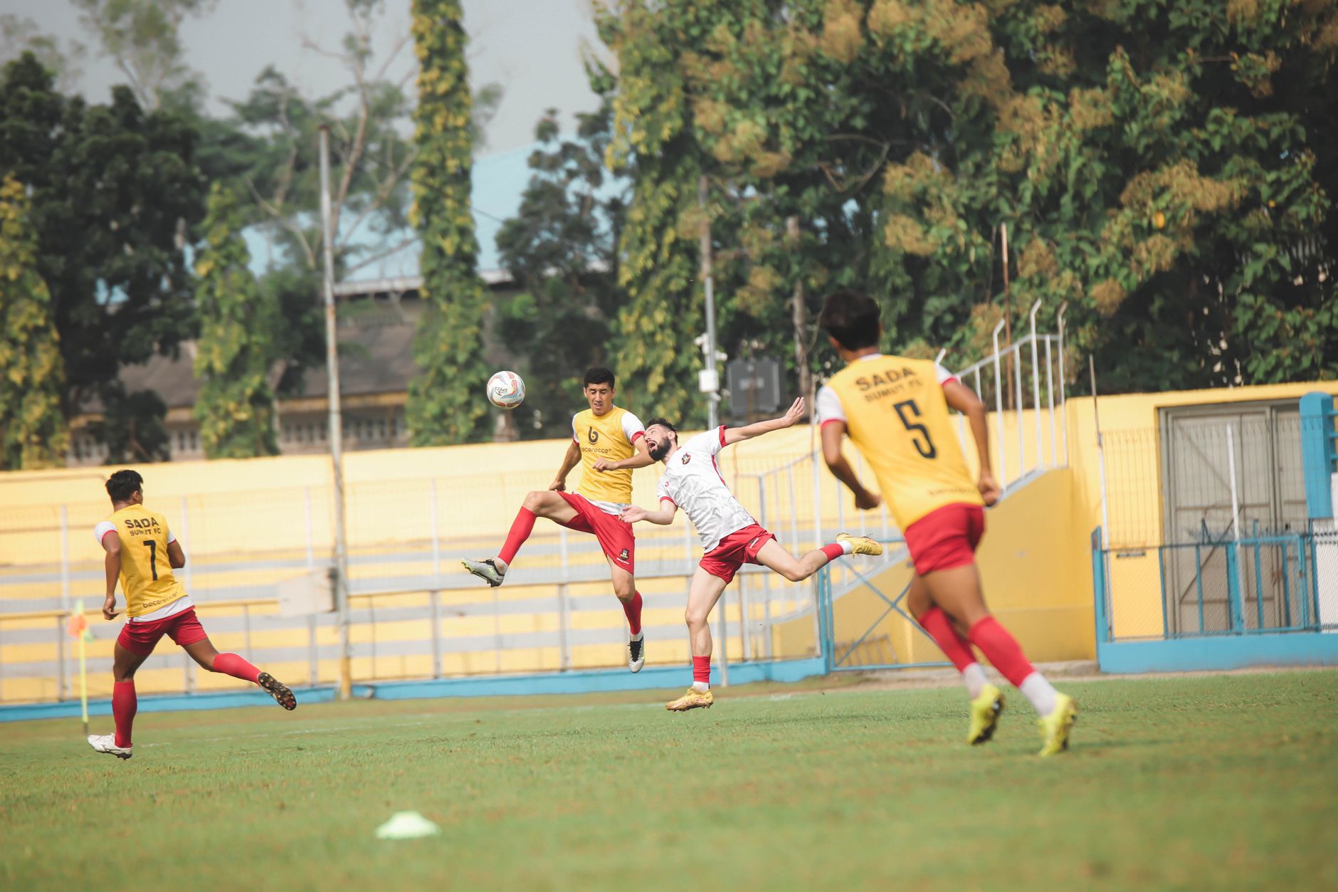 Aksi cepat pemain menendang bola dalam pertandingan sepak bola di stadion penuh sorak penonton